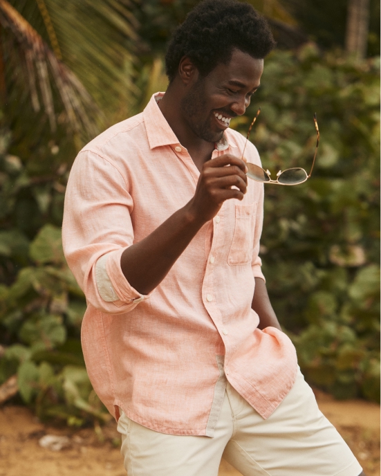 Man in a light shirt holding sunglasses