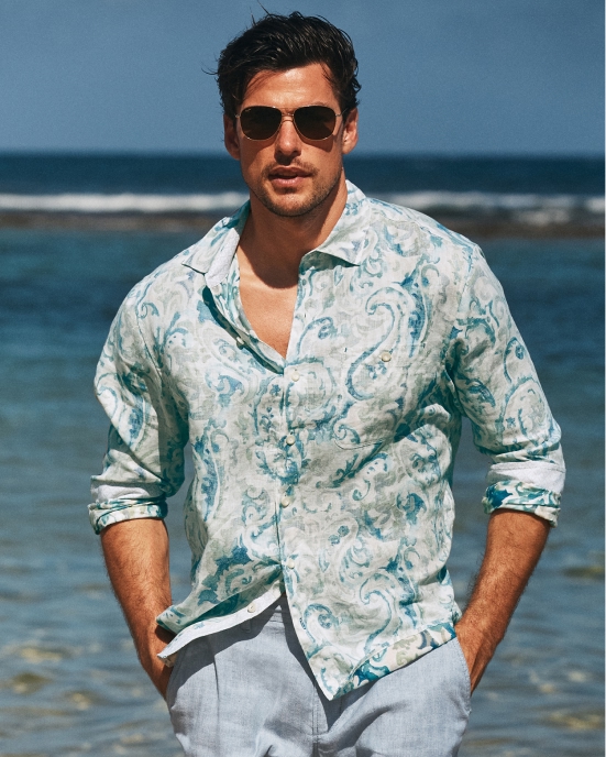 Man in a floral shirt holding a drink