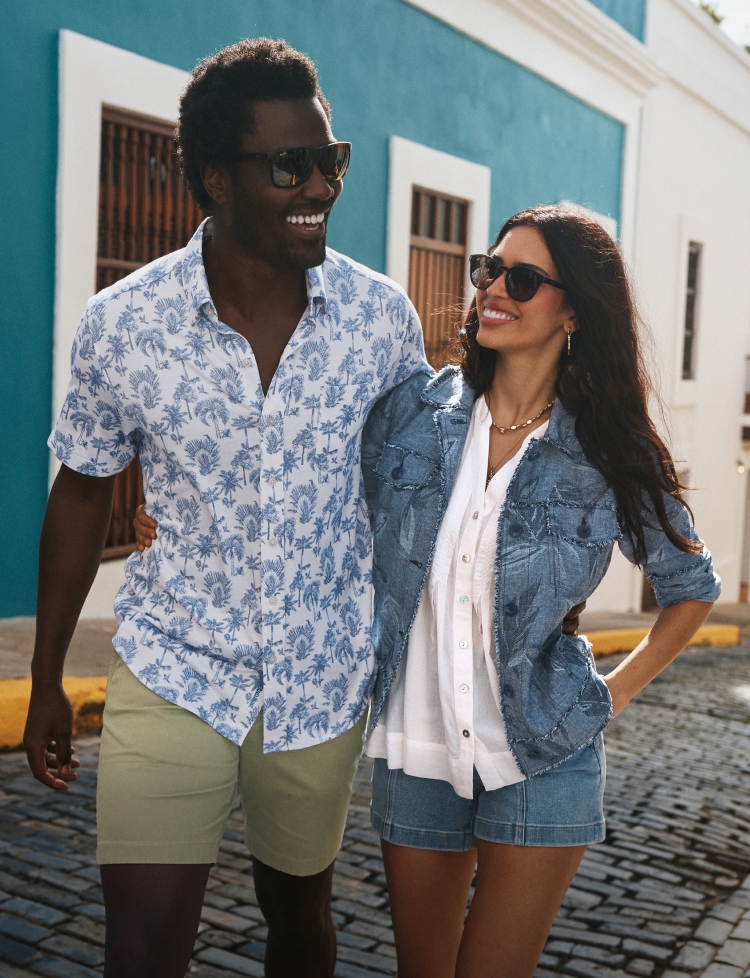 A couple walking together on a sunny street in resort wear
