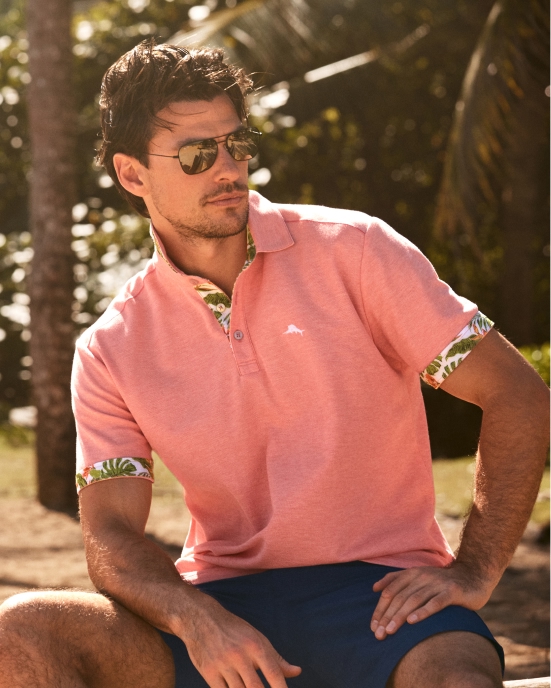 Man in a light shirt holding sunglasses
